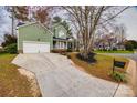 View of a light green home with white trim, long driveway, and well-manicured landscaping at 433 Runnymede Dr, Rock Hill, SC 29732
