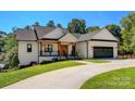 Inviting white brick home featuring a 2-car garage, covered porch, and well-maintained landscaping at 4808 1St Nw St, Hickory, NC 28601