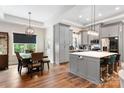 Open kitchen and dining area with grey cabinetry, island with seating, and modern lighting at 4808 1St Nw St, Hickory, NC 28601