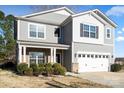 Two-story home with gray siding, white trim, manicured bushes, and a two-car garage at 5703 Eleanor Rigby Rd, Charlotte, NC 28278