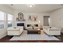 Bright living room featuring neutral furniture, decorative fireplace, and hardwood floors at 5703 Eleanor Rigby Rd, Charlotte, NC 28278