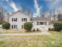 A full frontal view of a white brick home with a white porch and neatly trimmed bushes at 5743 Cherrycrest Ln, Charlotte, NC 28217