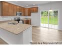 Modern kitchen featuring stainless appliances, stone countertops, light wood floors, and sliding glass doors to the yard at #603 Mt. Mitchell Ave # 603, Gastonia, NC 28052