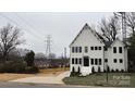 A two-story white home with black trimmed windows and a concrete driveway at 621 Poindexter Dr, Charlotte, NC 28209