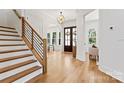 Open foyer with hardwood flooring, staircase with wood treads, and a view of the front door at 621 Poindexter Dr, Charlotte, NC 28209
