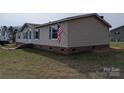 Side view of a well-maintained home, showing the vinyl siding and brick foundation at 7051 Maple Glen Dr, Catawba, NC 28609