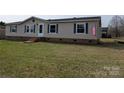 Traditional single-story home with vinyl siding and a well-manicured lawn and American flag at 7051 Maple Glen Dr, Catawba, NC 28609