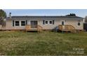 Rear of the home with sliding glass doors, wooden deck and well-kept lawn at 7051 Maple Glen Dr, Catawba, NC 28609