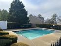 Community pool surrounded by lush greenery on a sunny day at 7141 Adare Mews Rd, Charlotte, NC 28217