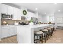 White kitchen features a large island with seating and stainless appliances at 781 Hazel Way, Denver, NC 28037