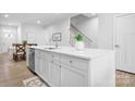 Bright kitchen island featuring a stainless steel sink, white cabinets and quartz countertops at 781 Hazel Way, Denver, NC 28037