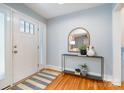 Welcoming entryway featuring hardwood floors, console table with decor, and a white front door at 917 Bobby Ln, Charlotte, NC 28211