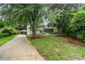 Beautiful home with a spacious front yard, mature trees, and long driveway to a carport at 917 Bobby Ln, Charlotte, NC 28211
