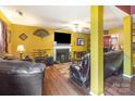 Cozy living room featuring hardwood floors, fireplace, large TV, and ample seating with leather sofas at 10228 Seedling Ln, Charlotte, NC 28214
