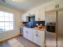 Well-lit kitchen features stainless steel appliances, white cabinets, a sink, and a subway tile backsplash at 1057 Farm Pond Ln, Rock Hill, SC 29732