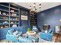 Well-appointed study with custom built-in shelving, a chandelier and comfortable seating at 2007 Fernhurst Ter, Matthews, NC 28104