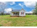 View of the home with white siding, a cozy front porch with seating and red shutters at 2455 Wellridge Rd, Chester, SC 29706