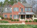 Charming brick home showcasing a covered porch, manicured landscaping, and inviting curb appeal at 2538 Cherry Bark Oak Ct, Gastonia, NC 28056