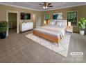 Staged main bedroom with ceiling fan, dresser, and ensuite access at 2927 Clemson Ave, Charlotte, NC 28205