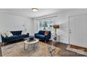 Inviting living room features hardwood floors, white walls, blue seating and natural light at 3036 Marlowe Ave, Charlotte, NC 28208