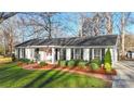Charming single-story home boasts meticulously landscaped front yard and cozy rocking chairs on the porch at 3830 Lovett Cir, Charlotte, NC 28210