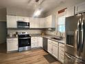 Well-lit kitchen with stainless steel appliances, granite countertops, and modern light fixture at 409 Fourth St, York, SC 29745