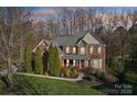 Beautiful two-story brick home with a manicured lawn and mature landscaping at 653 Buckleigh Nw Ct, Concord, NC 28027