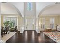 Grand foyer with soaring ceilings, arched entryways, and dark hardwood floors at 653 Buckleigh Nw Ct, Concord, NC 28027