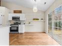 Charming kitchen with modern appliances, white cabinets, and an adjacent dining nook with sliding glass door at 7047 Whittingham Dr, Indian Land, SC 29707
