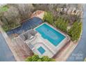 Aerial view of the community pool, playground, basketball court, and parking area surrounded by tall, mature trees at 7047 Whittingham Dr, Indian Land, SC 29707