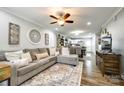 Spacious living room featuring hardwood floors, ceiling fan, and open floor plan leading to kitchen at 730 Shuttles Way, Fort Mill, SC 29715