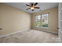 A bedroom with neutral walls, carpet, a ceiling fan and one window allowing for natural light at 10129 Loch Lomond Dr, Charlotte, NC 28278