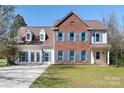 Charming two-story home featuring brick and siding exterior, blue shutters, and a well-manicured lawn at 105 Easy St, Mooresville, NC 28117
