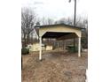 A view of the covered parking area and some sheds sits against a backdrop of bare trees on a cloudy day at 1140 Mt Vernon Rd, Woodleaf, NC 27054