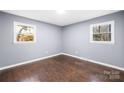 Bedroom featuring hardwood floors, two windows, freshly painted gray walls and trim at 1203 Northwoods Dr, Kings Mountain, NC 28086