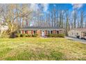 Traditional brick home with red shutters, showcasing a neat front yard and mature trees at 1203 Northwoods Dr, Kings Mountain, NC 28086
