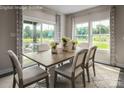 Elegant dining room with large windows, stylish curtains, and a light wood table at 1240 Cottage Green Dr # 0132, Monroe, NC 28112