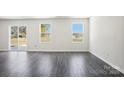 Bright living room featuring hard wood floors, neutral paint, several windows, and sliding glass doors at 1542 Cannan Mountain Dr, Newton, NC 28658