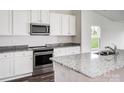 Modern kitchen with stainless steel appliances, granite countertops, and white cabinetry at 159 Wembury Ln, Troutman, NC 28166