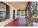 Inviting covered front porch with brick columns, swing, and view to the front yard at 211 W 6Th Ave, Gastonia, NC 28052