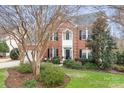 Inviting two-story brick home with black shutters, trimmed bushes, and a well-maintained lawn at 215 Whitegrove Dr, Fort Mill, SC 29715