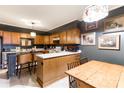 Well-lit kitchen with breakfast bar, wood cabinets, tile floors, and unique light fixtures at 300 N Fulton St # 12, Salisbury, NC 28144