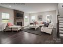 Cozy living room featuring a stone fireplace, hardwood floors, and comfortable seating arrangement at 3022 Bramble Hedge Rd # 3269, Indian Trail, NC 28079