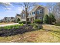 Charming two-story home featuring a stone facade, red door, well-manicured lawn, and mature trees at 4035 W Sandy Trl, Fort Mill, SC 29707