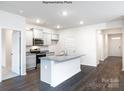 Bright, open kitchen with stainless steel appliances, granite counters, and dark hardwood floors at 5231 Reedy Ridge Rd, Charlotte, NC 28215