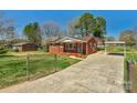 Well-maintained brick home with a long driveway and a carport providing ample parking at 602 Dallas Spencer Mountain Rd, Dallas, NC 28034
