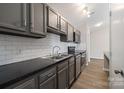 Modern kitchen with stainless steel appliances, gray cabinets, and subway tile backsplash at 6142 Meadow Rose Ln, Charlotte, NC 28215