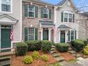 Stylish townhome facade with green shutters, brick accents, and a neatly maintained front yard at 6936 Colonial Garden Dr, Huntersville, NC 28078