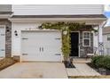 Inviting townhome featuring a one-car garage and vine-covered entryway, creating a warm welcome at 7217 Somerford Rd, Charlotte, NC 28215