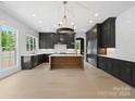 Bright, open kitchen boasts dark cabinetry, a light countertop island, and high-end stainless steel appliances at 733 Barbary Pl, Lincolnton, NC 28092